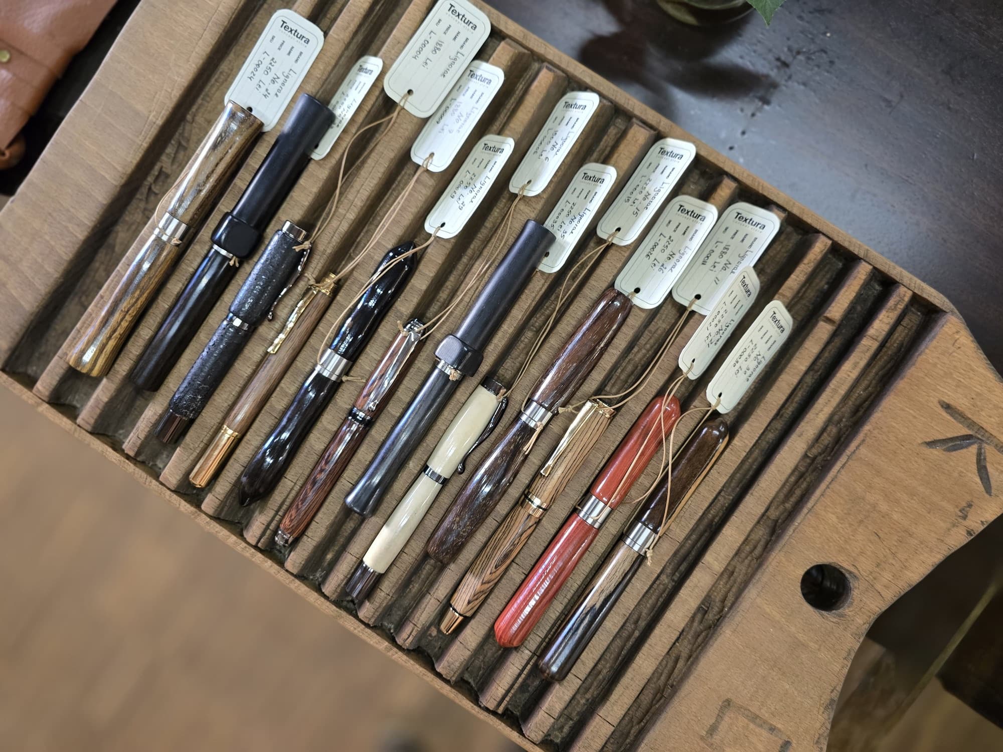 LIGNORAE numbered writing instruments arranged in a carved wooden tray at TEXTURA